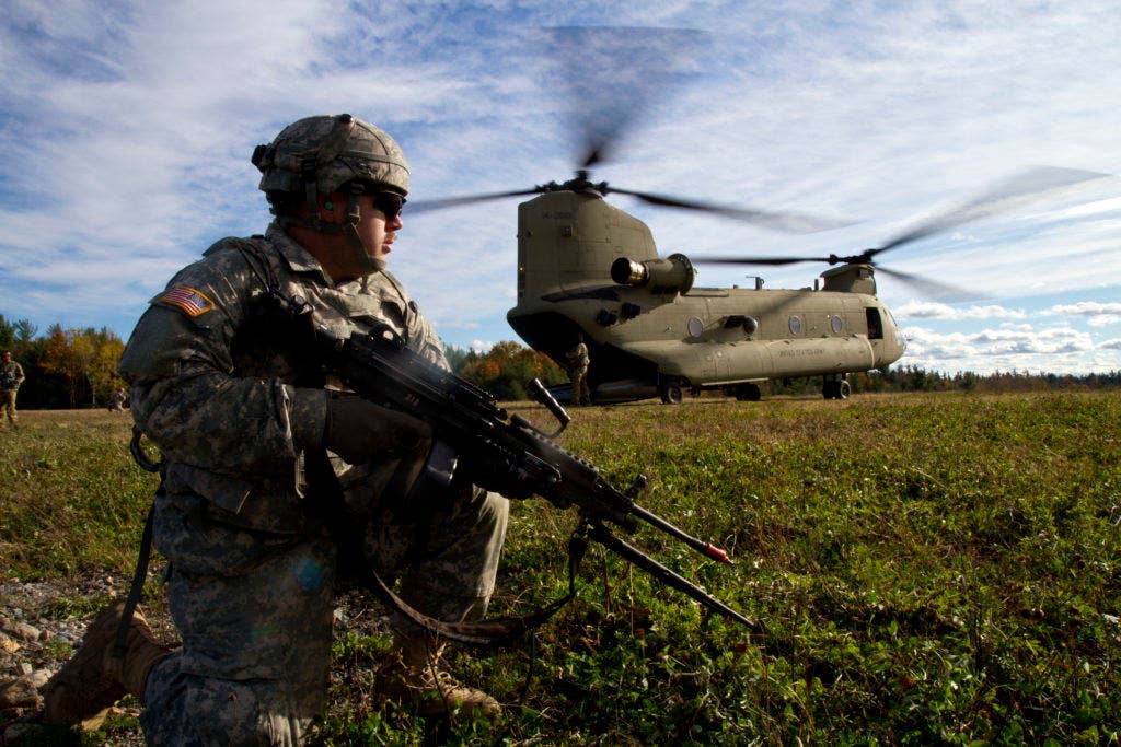 A military policeman pulls security as other soldiers load a CH-47 during non-combatant evacuation training. (Photo: U.S. Army Spc. Thomas Scaggs)