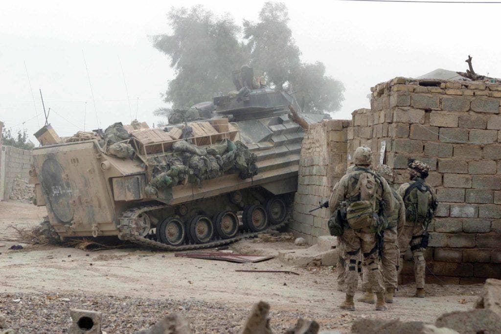 An Amphibious Assault Vehicle (AAV) drives through a wall and locked gate to open a path for Marines assigned to 2nd Platoon, India Company, 3rd Battalion, 1st Marines, 1st Marine Division, as they gain entrance to a building that needed to be cleared in Fallujah, Iraq, during Operation Al Fajr (New Dawn). Operation Al Fajr is an offensive operation to eradicate enemy forces within the city of Fallujah in support of continuing security and stabilization operations in the Al Anbar province of Iraq. (U.S. Marine Corps photo by Lance Cpl. Ryan L Jones)