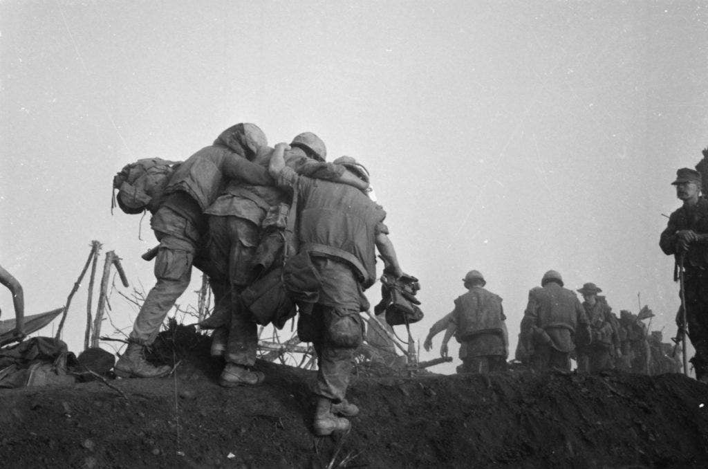 A Marine is helped to an evacuation point by two buddies after he was wounded during an enemy probe of his unit's position during Operation Dewey Canyon. Marines killed 12 North Vietnamese in the fighting northwest of the A Shau Valley. (Photo: U.S. National Archives)