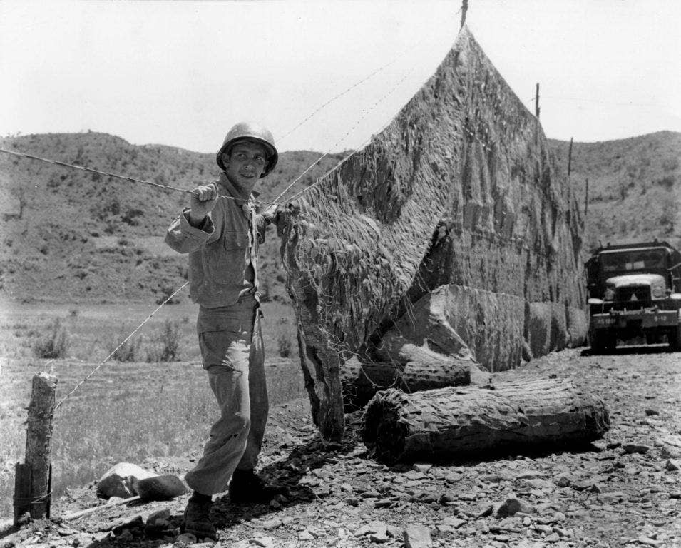 A soldier of the 120th Engineer Battalion, 45th Infantry Division sets up camouflage net near the front lines in Korea in 1952. (U.S. Army photo)