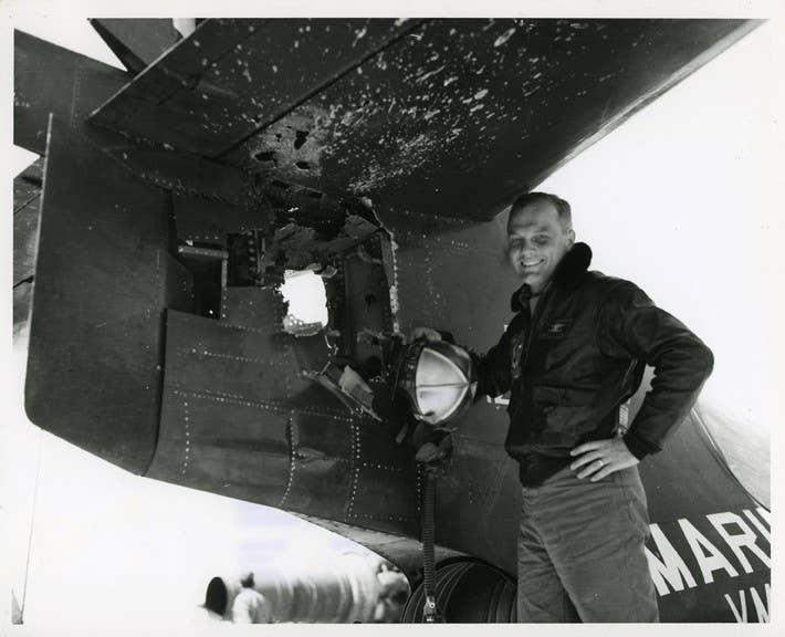 John Glenn standing beside the damage to the tail of his F9F Panther from antiaircraft fire after a mission during the Korean War. Gene Cernan flew the F9F Panther during flight training. (Ohio State University)