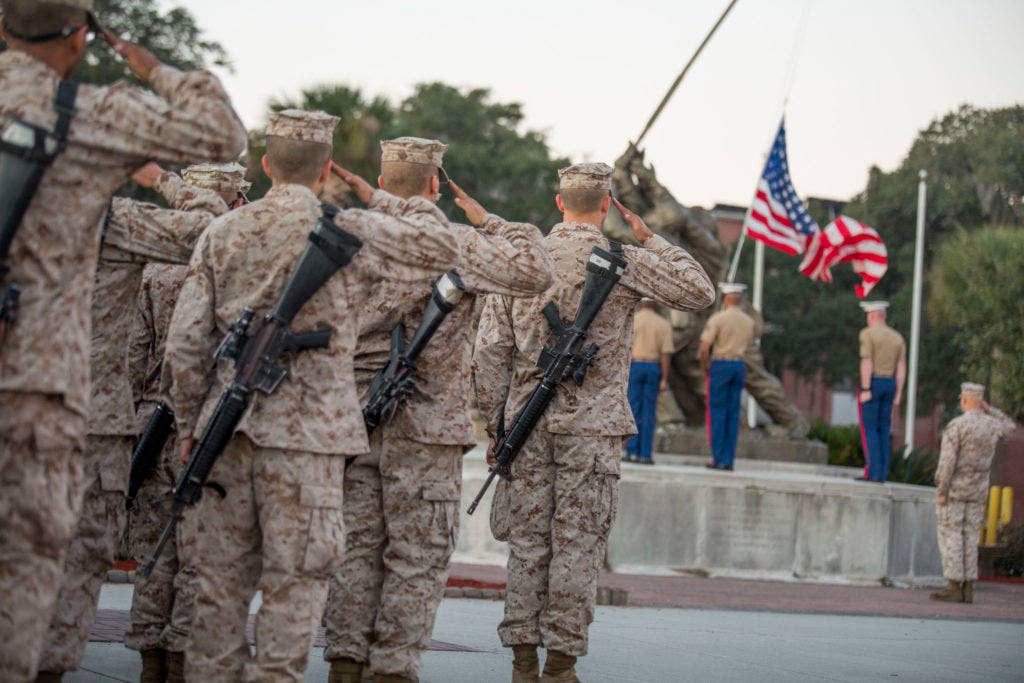 Recruits of Kilo Company, 3rd Recruit Training Battalion, salute the nation's colors during an emblem ceremony Oct. 25, 2014, on Parris Island, S.C. (Photo by Cpl. Caitlin Brink)