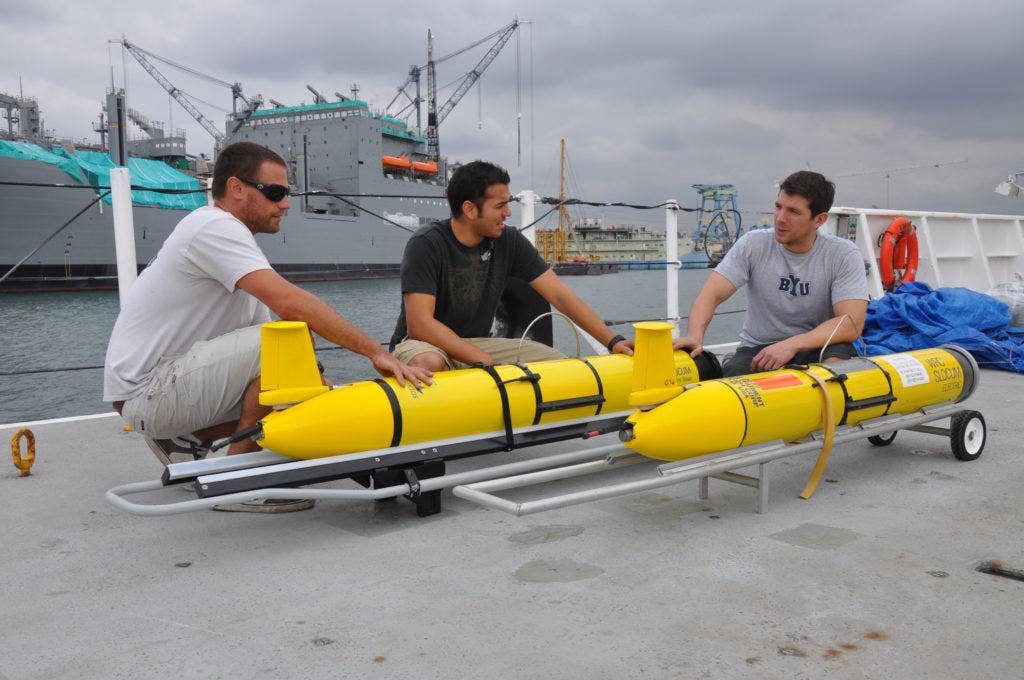 Daniel Braun, left, Eric Sanchez and David Barney, Systems Center Pacific engineers at Space and Naval Warfare Systems Command (SPAWAR), perform pre-deployment inspections on littoral battlespace sensing gliders aboard the Military Sealift Command oceanographic survey ship USNS Pathfinder (T-AGS 60). Each glider hosts a payload suite of sensors that will measure the physical characteristics of the water column as the glider routinely descends and ascends in the ocean. The gliders will be deployed during an at-sea test aboard Pathfinder Oct. 22-Nov. 5. (U.S. Navy photo by Rick Naystatt)