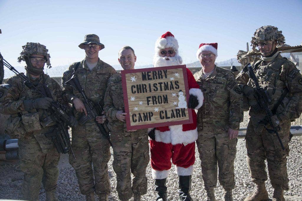Gilliand Hudson, a carpenter with FLOUR, acts as Santa Claus and poses alongside U.S. soldiers with 4th Battalion, 25th Field Artillery Regiment, 3rd Brigade Combat Team, 10th Mountain Division, on Forward Operating Base Clark, Afghanistan, Dec. 25, 2013. Hudson dressed as Santa Claus to spread holiday cheer for soldiers away from home for the holidays. (U.S. Army photo by Cpl. Amber Stephens / Released)