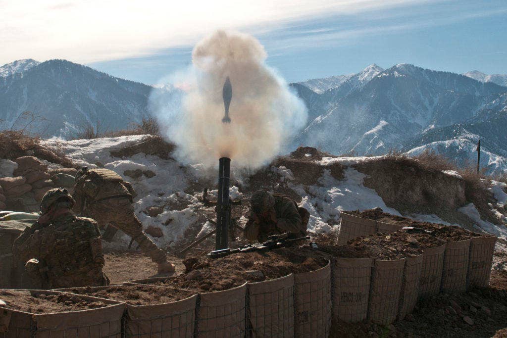 A 120 mm mortar round flies out of the tube as U.S. Army soldiers take cover at Observation Post Mustang in eastern Afghanistan's Kunar province on Jan. 26, 2016. (U.S. Army photo)