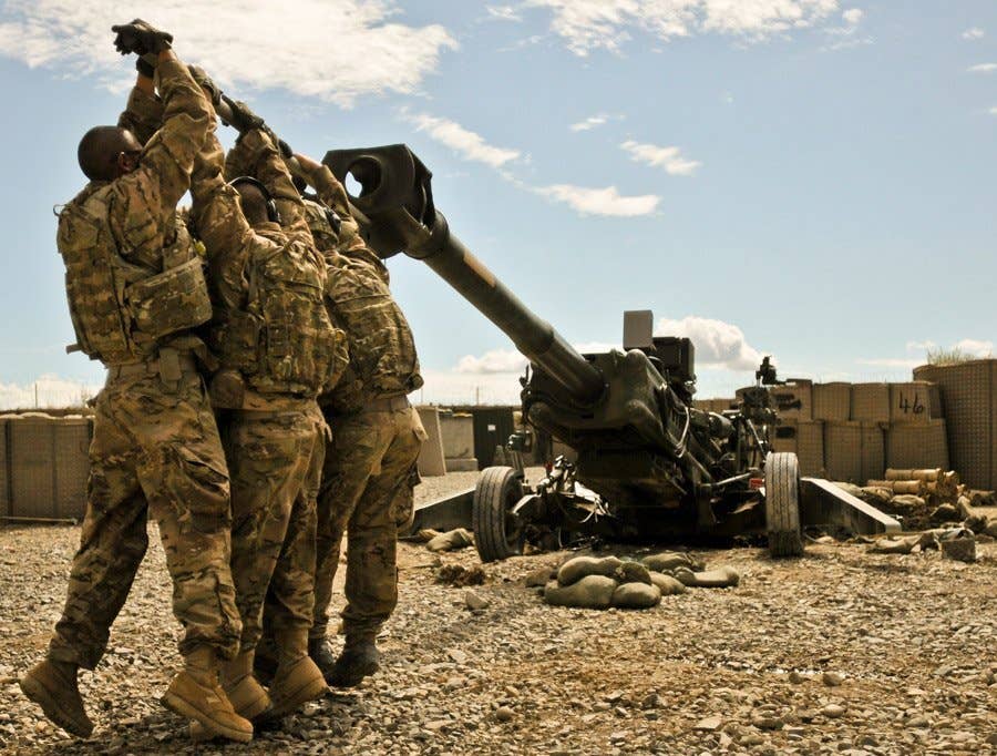 Members of 3rd Platoon, Alpha Battery, 1st Battalion, 77th Field Artillery Regiment, 172nd Infantry Brigade, work at dislodging their M-777 155mm howitzer from the three-foot deep hole it dug its spades into after firing several rocket-assisted projectiles. The huge weapon weighs 9,000 pounds and can launch projectiles over 30 kilometers. (U.S. Army photo by Spc. Ken Scar)