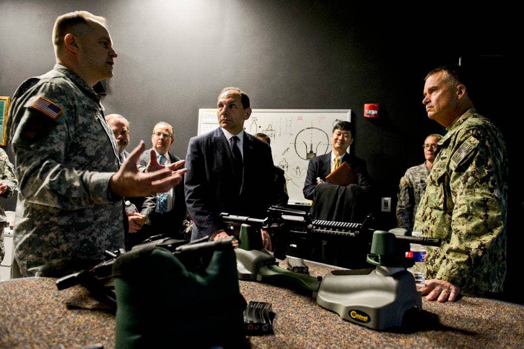 Vice Chairman of the Joint Chiefs of Staff Adm. James A. Winnefeld, Jr. and (left) Department of Veterans Affairs Secretary Robert McDonald (center) receive a brief on a firearms training driving simulator during a tour of the Center for the Intrepid, Dec. 19, 2014. (U.S. Air Force photo by Staff Sgt. Jonathan Snyder)