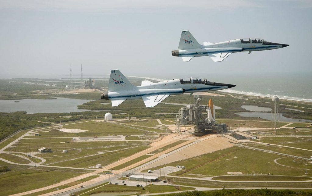 Two NASA T-38s fly past the Space Shuttle launch pad. Gene Cernan got 15 flight hours a month in the T-38 to maintain proficiency as an astronaut. (NASA photo)