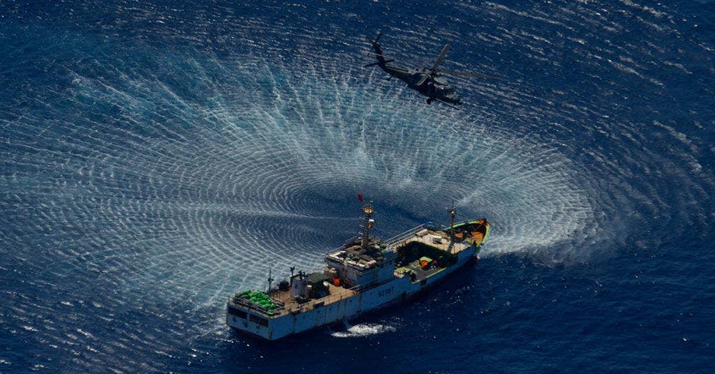 An HH-60G Pave Hawk rescue helicopter from the 129th Rescue Wing hovers over the Chinese fishing vessel Fu Yuan Yu #871, March 12, 2012. Guardian Angel Pararescuemen from the wing rescued two fishermen who were burned in a diesel fire onboard the vessel more than 700 miles off the coast of Acapulco, Mexico. (Air National Guard photo by Airman 1st Class John Pharr)