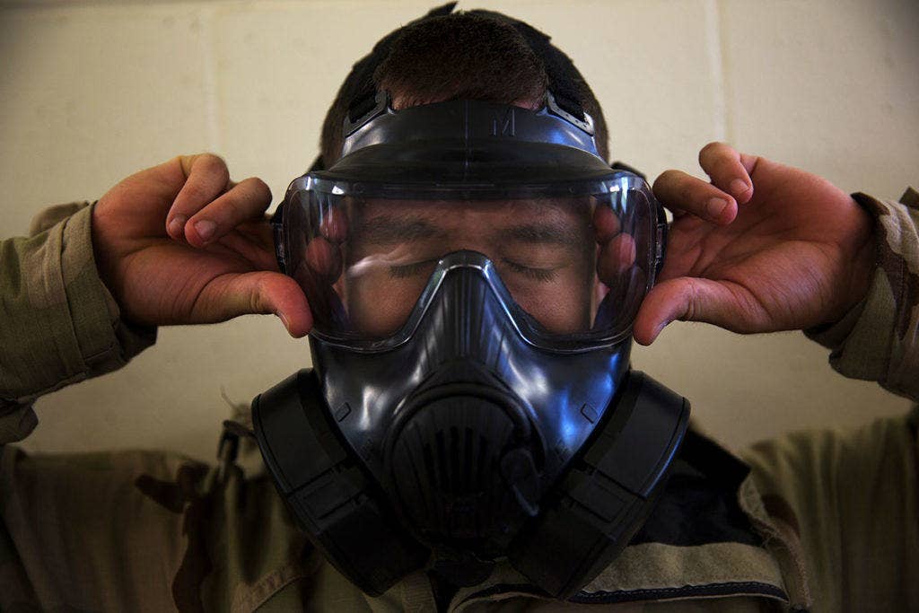 A Marine makes sure his gas mask has a proper seal to keep contaminants away from his face. Beards can inhibit a proper seal. (U.S. Marine Corps photo)
