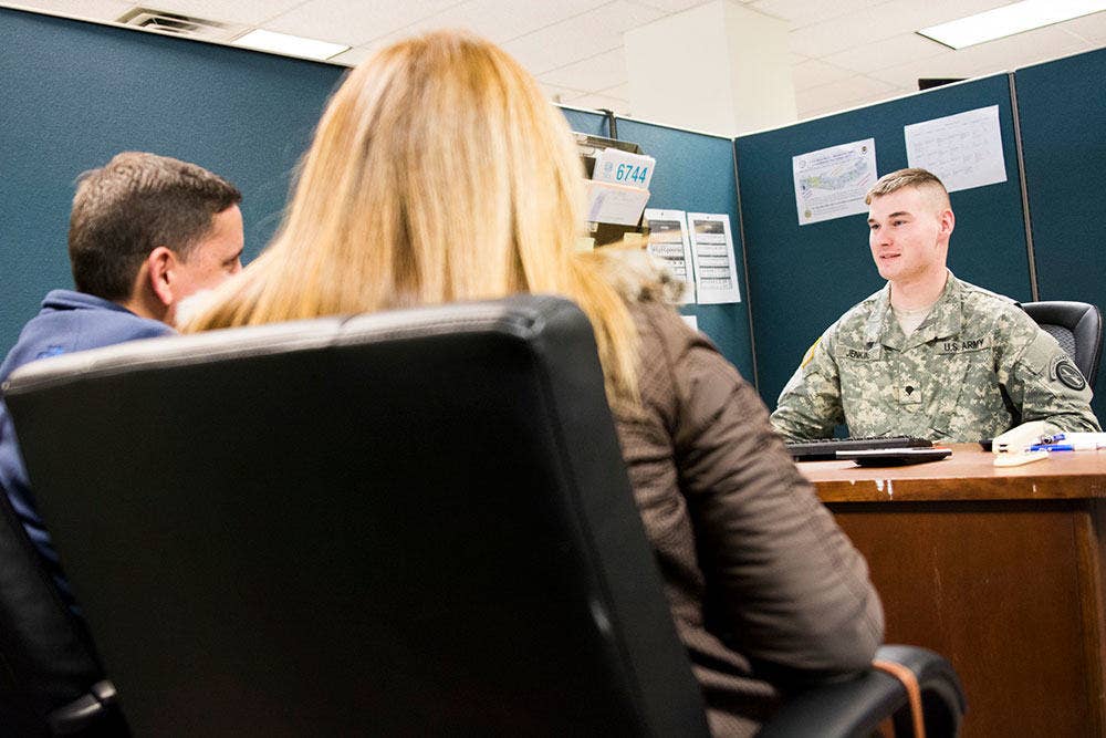 Army Spc. Coltin Jenkins, tax preparer, works with customers of the Joint Base Myer-Henderson Hall Consolidated Tax center in Building 205 on the Fort Myer portion of the joint base March 17, 2015. (Joint Base Myer-Henderson Hall PAO photo by Rachel Larue)