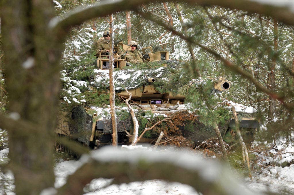 Soldiers assigned to 1st Battalion, 68th Armor Regiment, 3rd Armored Brigade, 4th Infantry Division sit in an M1 Abrams Tank after concealing it in wooded terrain, Jan 20, at Presidential Range in Swietozow, Poland. (Photo: U.S. Army Staff Sgt. Elizabeth Tarr)