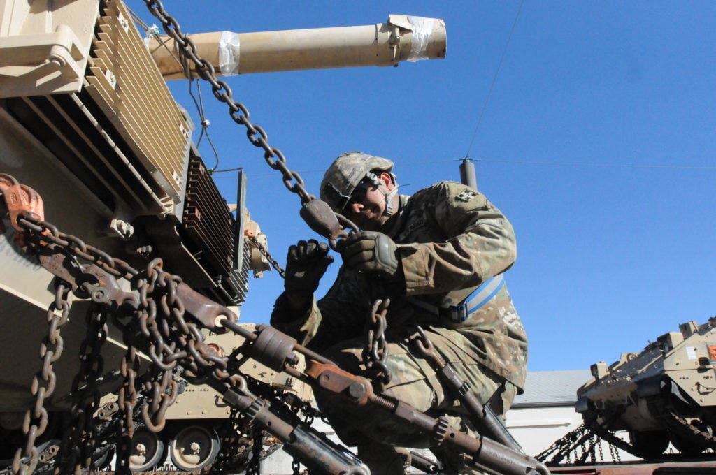 Sgt. Arnulfo Ramos, an M1A2 Abrams tank crewman for Company Bravo, 1st Battalion, 66th Armor Regiment, 3rd Armored Brigade Combat Team, 4th Infantry Division, secures the chains on a tank after it was loaded on to a rail car at Fort Carson, Colorado, Nov. 15, 2016. (Photo: U.S. Army Ange Desinor)