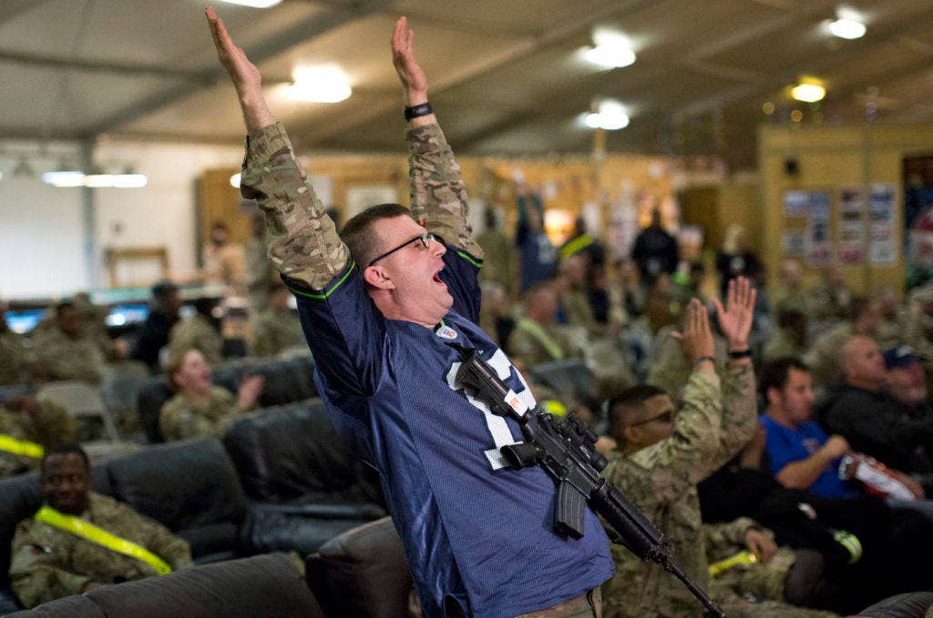 Capt. Joe Beale, a systems automation officer assigned to the 57th Expeditionary Signal Battalion, cheers as the Seattle Seahawks score a touchdown during Super Bowl XLVIII, Feb. 2, 2014, at Kandahar Airfield, Afghanistan. (Photo: U.S. Army Cpl. Alex Flynn)