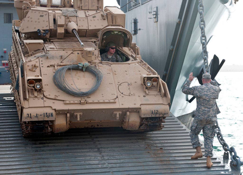 A Bradley Fighting Vehicle rolls off the ramp of an Army Logistics Support Vessel during a training exercise. Army watercraft are designed to operate in austere to bare beach environment and are not dependent upon developed seaports or infrastructure. (Photo: U.S. Army Master Sgt. Dave Thompson)
