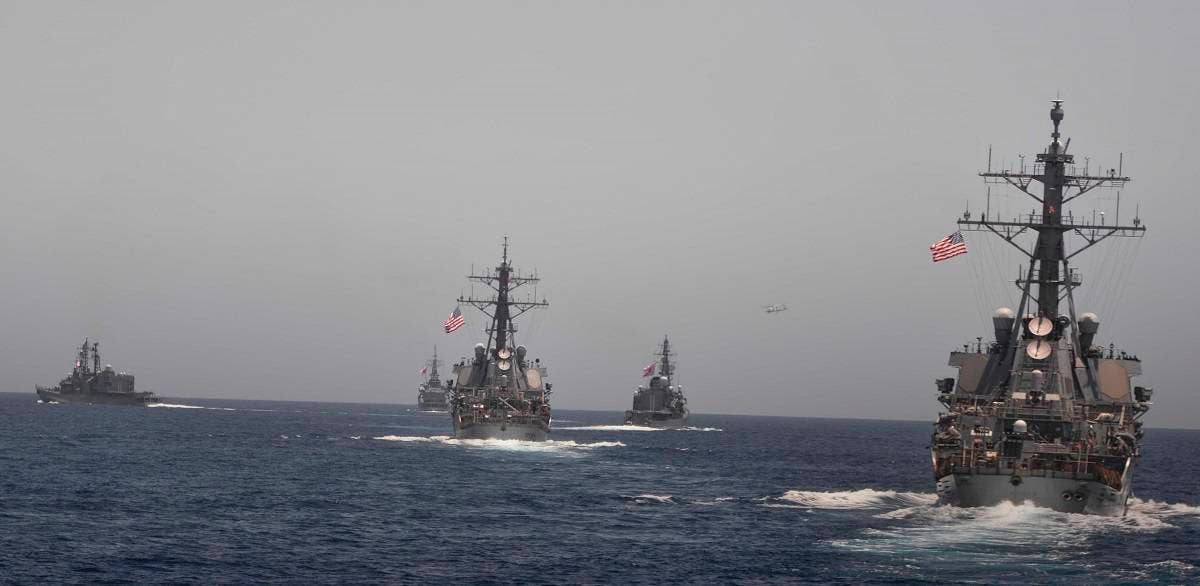 Arleigh Burke-class guided-missile destroyers USS Mahan (DDG 72) and USS Cole (DDG 67) maneuver into position behind three Japanese destroyers during a photo exercise. USS Cole is in the center of the photograph. (U.S. Navy photo by Mass Communication Specialist 1st Class Tim Comerford/Released)