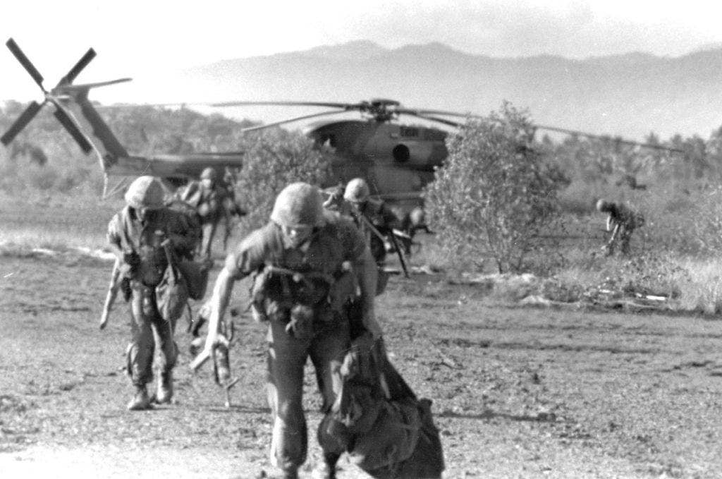 U.S. Marines run from a heavily-damaged HH-53C helicopter during the SS Mayaguez operation. (U.S. Air Force photo)