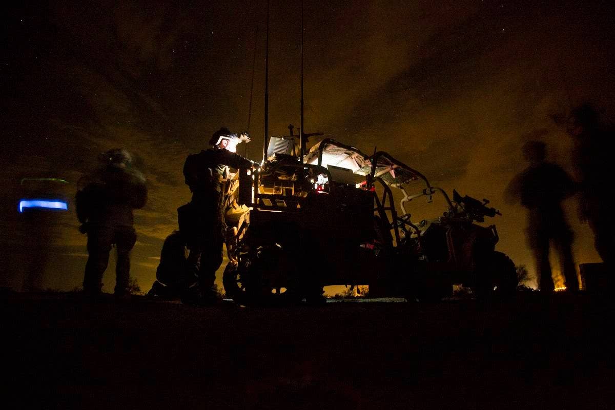 Marines with Marine Special Operations Company Charlie, 1st Marine Raider Battalion, U.S. Marine Corps Forces, Special Operations Command, process intelligence and set up a visual tele-communication feed after a simulated direct-action night raid during a company level exercise along the state line between Arizona and California, Oct. 20, 2015. Special operations are conducted in hostile, denied or politically sensitive environments, requiring heavy emphasis on combat support capabilities, modes of employment, and dependence on operational intelligence and indigenous assets. (U.S. Marine Corps photo by Cpl. Steven Fox, released)
