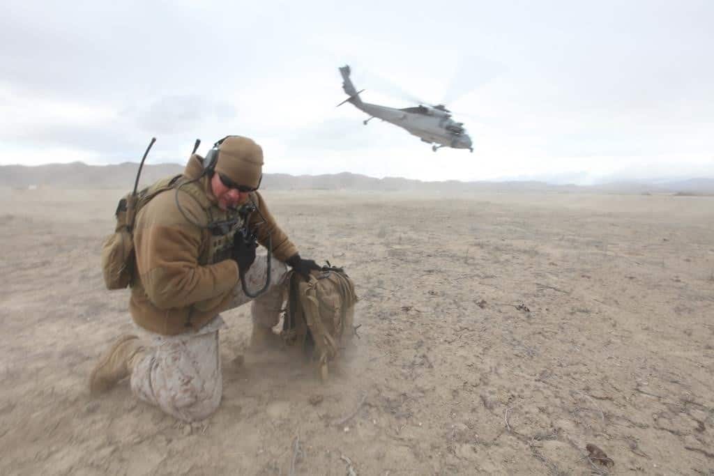 A Joint Terminal Attack Controller with U.S. Marine Corps Forces, Special Operations Command communicates with a Navy MH-60S helicopter during takeoff as part of Carrier Airwing training conducted by the Naval Strike and Air Warfare Center aboard Naval Air Station Fallon, Nev., April 7, 2011. During the exercise, MARSOC JTACs practiced their critical skills and renewed their currencies and qualifications. Special Operations Capability Specialists are essential members of Marine Special Operations Teams and provide combat support in fires, intelligence, multipurpose canine handling and communications, enabling MARSOC units to execute core special operations missions. (U.S. Marine Corps photo by Cpl. Kyle McNally, released)