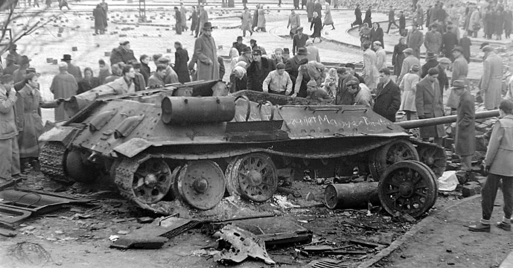 Citizens of Budapest examine a Soviet tank destroyed by rebels. (Photo: Wikimedia Commons)