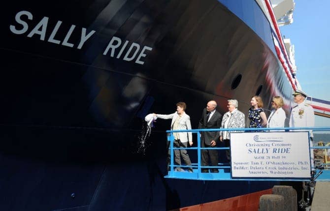 Dr. Tamara E. O'Shaughnessy, Sally Ride's sponsor, breaks a bottle across the ship's bow during her christening at Dakota Creek's shipyard in Anacortes, Wash., 4 August 2014. Joining O'Shaughnessy on the platform are Dick Nelson, president, Dakota Creek Industries, Inc., the reverend Dr. Bear Ride, matron of honor, Kathleen Ritzman, assistant director, Scripps Institution of Oceanography, University of California San Diego, Kathryn Sullivan, undersecretary of commerce for oceans and atmosphere and administrator, National Oceanic and Atmospheric Administration, and Rear Adm. Matthew Klunder, Chief of Naval Research. (US NAvy photo)