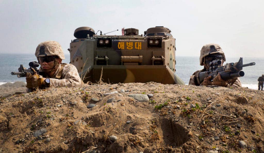 Marines wait for the command to advance after rushing out of a Republic of Korea Marine amphibious assault vehicle March 31, 2014, during Ssang Yong 2014 at Dokseok-ri beach in Pohang, Republic of Korea. | U.S. Marine Corps photo by Lance Cpl. Cedric R. Haller II