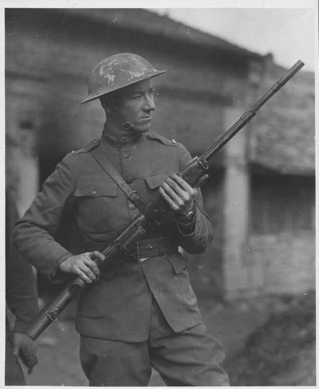 Army 2nd Lt. John M. Browning stands with the Browning Automatic Rifle designed by his father. (Photo: Army Heritage and Education Center)