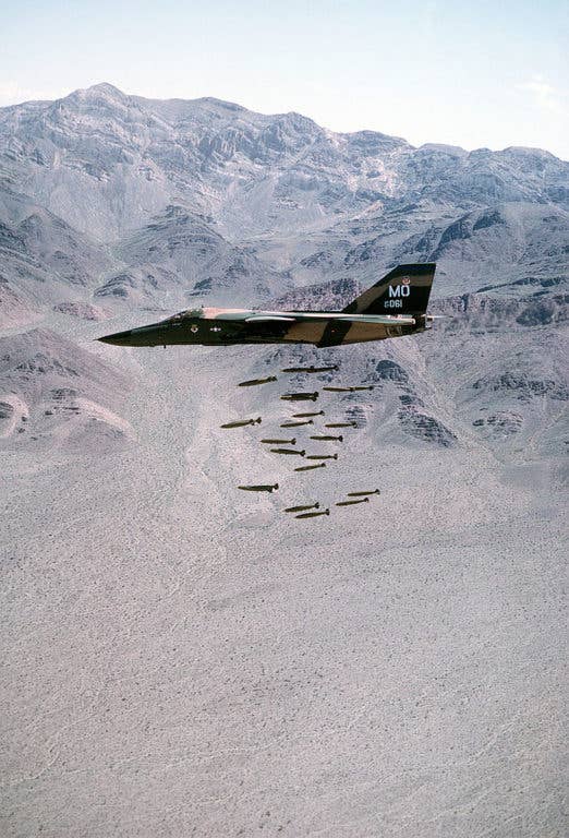 A left side view of an F-111A dropping 24 Mark 82 low-drag bombs in-flight over a range on May 1, 1980. The aircraft was assigned to the 391st Tactical Fighter Squadron, 366th Tactical Fighter Wing. (USAF photo)