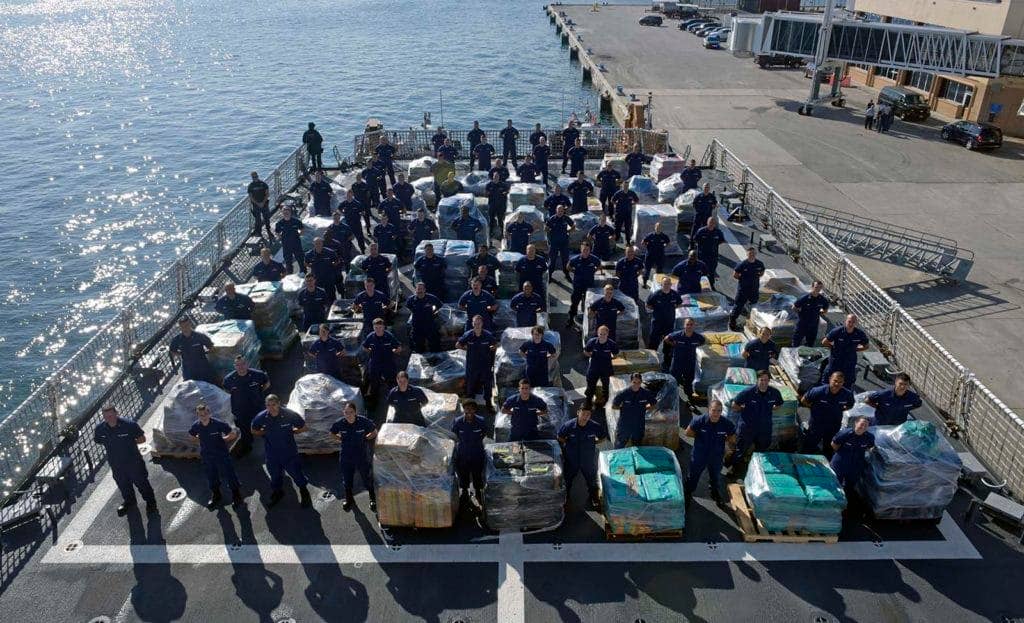 Members of the Coast Guard Cutter Hamilton crew stand next to approximately 26.5 tons of cocaine Dec. 15, 2016 aboard the cutter at Port Everglades Cruiseport in Fort Lauderdale, Florida. (Photo: U.S. Coast Guard Petty Officer 3rd Class Eric Woodall)