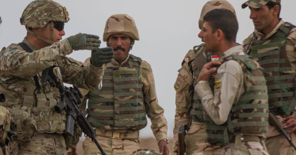 Spc. Alaa Jaza, an Arabic linguist, advises Iraqi Army soldiers on how to set battle positions to avoid friendly fire during a training event at Camp Taji, Iraq, Wednesday, March 25, 2015. (U.S. Army photo by Sgt. Cody Quinn, CJTF-OIR Public Affairs)