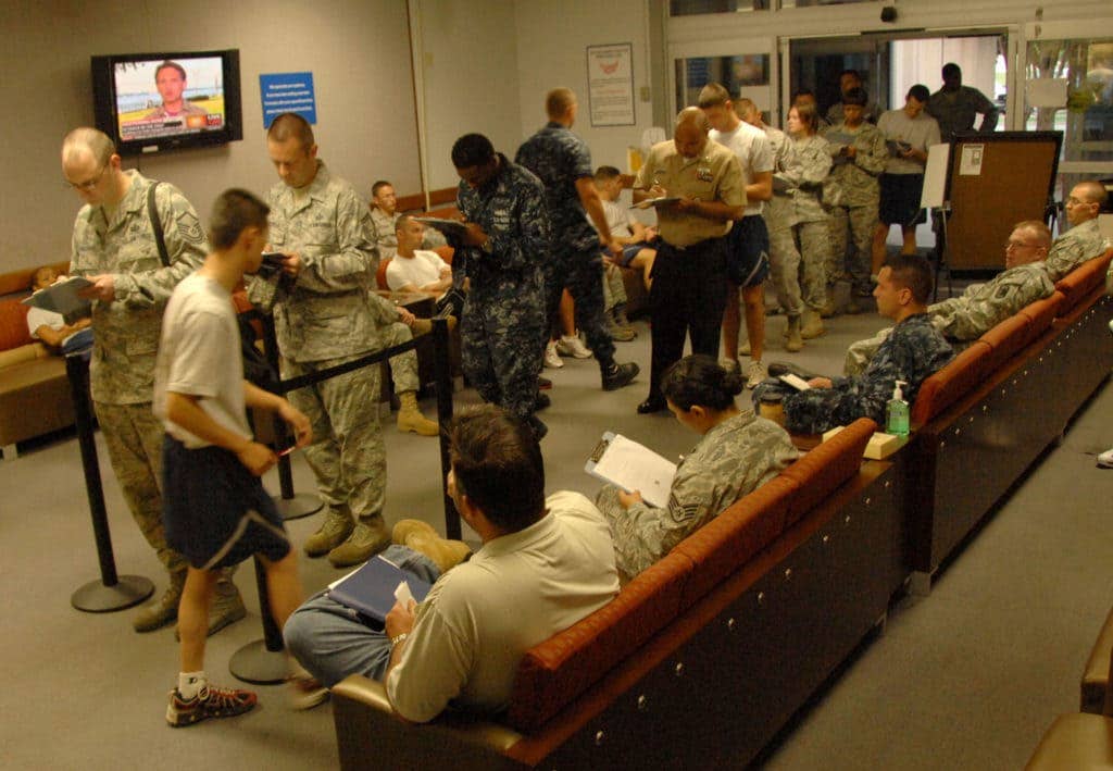 Military members wait in a sick call line. (Photo: Senior Airman Josie Walck)