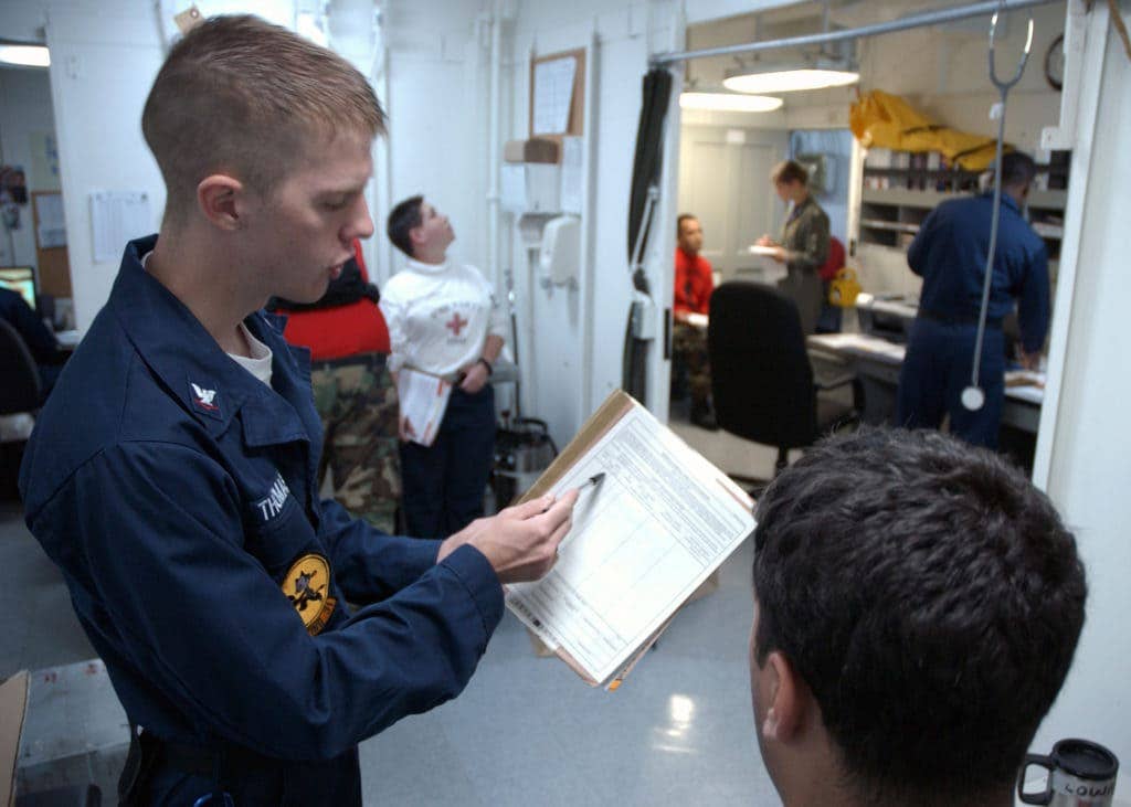 HM3 Tristian Thomas reviews a patient's medical record. (Photo by Photographer's Mate 3rd Class Randall Damm)