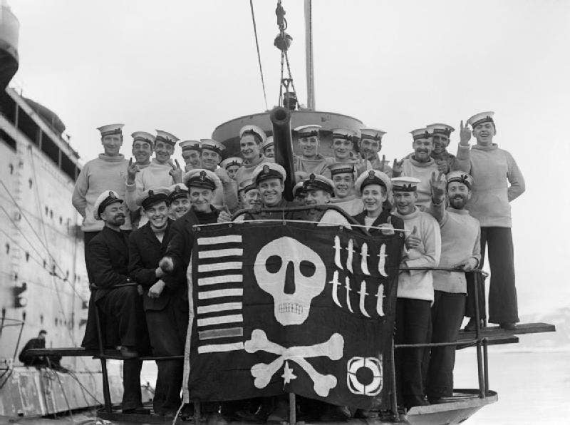 The British submarine HMS Utmost showing off their Jolly Roger in February 1942. The markings on the flag indicate the boat's achievements: nine ships torpedoed (including one warship), eight 'cloak and dagger' operations, one target destroyed by gunfire, and one at-sea rescue. (Imperial War Museum)