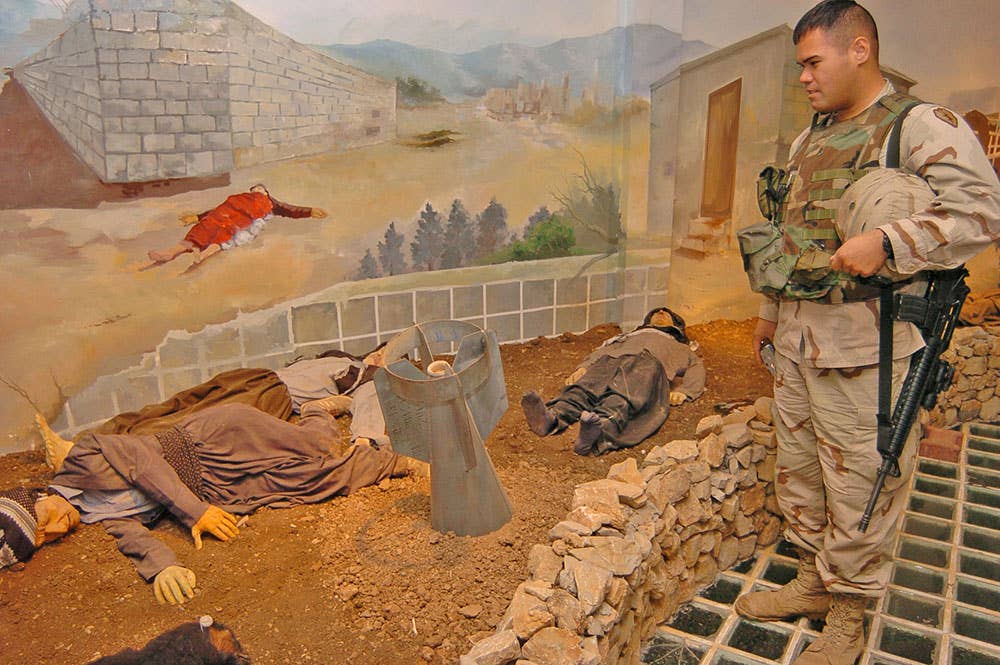 Sgt. Nolan Heanu, a mechanic with HHS, TF 2-11 FA, stops to check out a display portraying the 1988 gas attack inside the memorial in Iraq. The casing of the bomb sticking out of the ground came from an actual bomb used in the attack 16 years ago. (Sgt. Sean Kimmons)