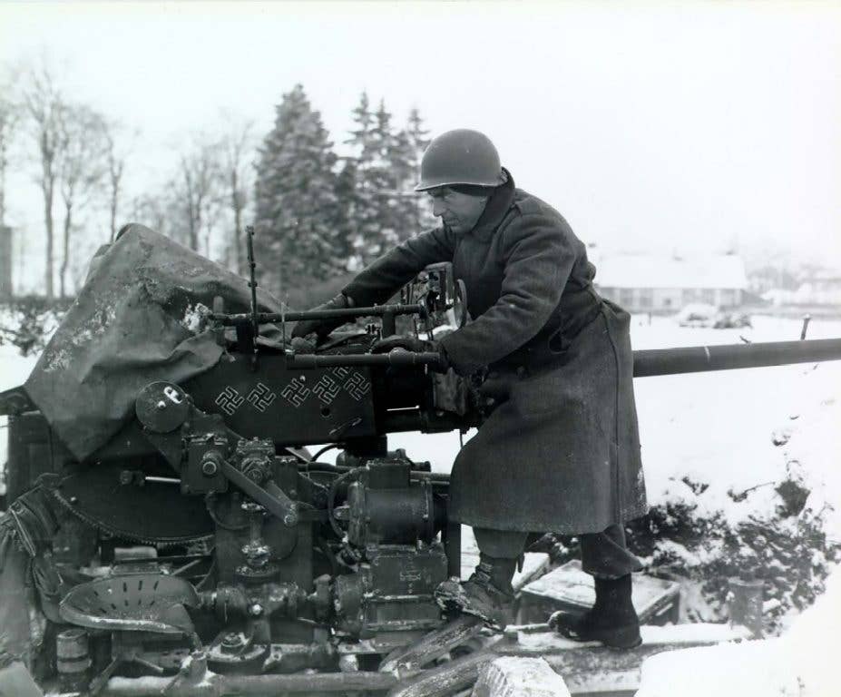 A U.S. Army soldier with the 1st Infantry Division prepares his anti-aircraft gun during World War II. The six swastikas indicate six enemy planes killed. (Photo: U.S. Army Sgt. Bill Augustine)