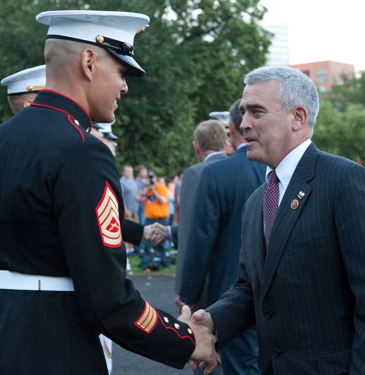 U.S. Rep. Brad Wenstrup of Ohio, right, a Sunset Parade guest of honor, exchanges greetings with a U.S. Marine Corps gunnery sergeant during a parade at the Marine Corps War Memorial in Arlington, Va., June 18, 2013. A Sunset Parade was held every Tuesday during the summer months. (U.S. Marine Corps photo by Cpl. Tia Dufour/Released)