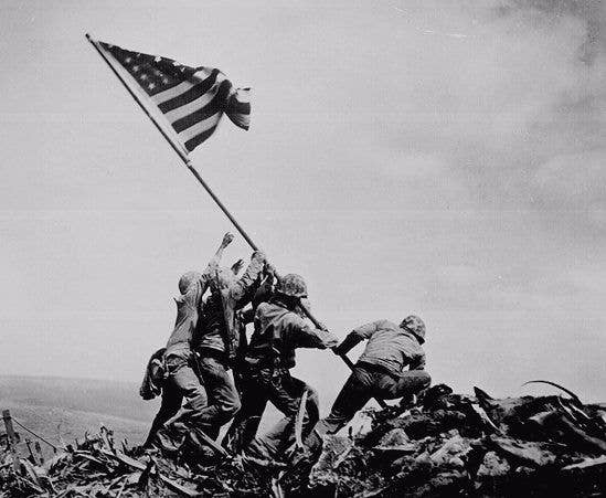 Five Marines and a Navy hospital corpsman raise the flag on Mount Suribachi, Iwo Jima.