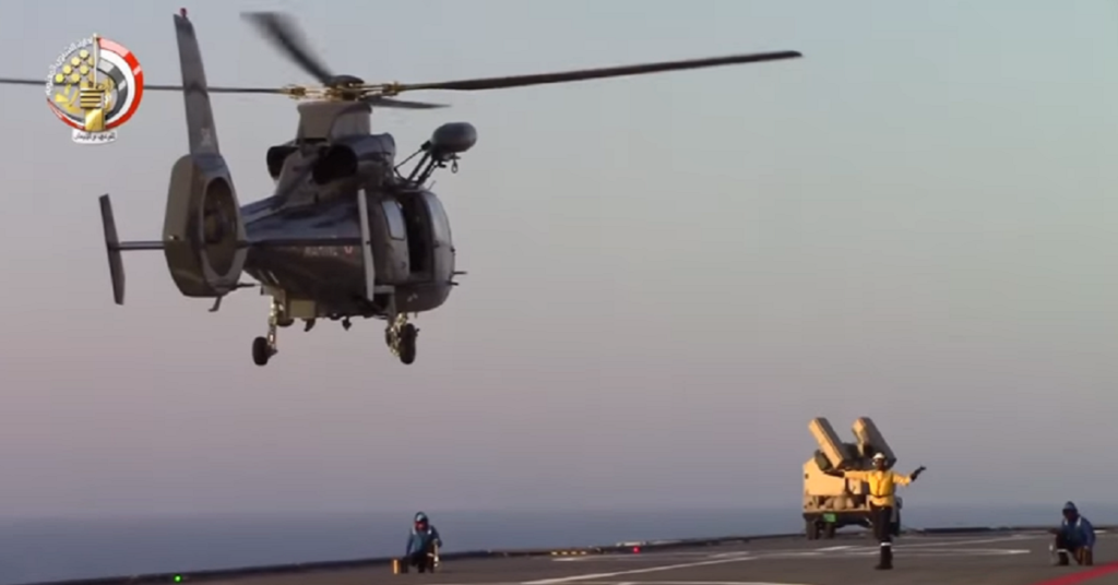 A helicopter comes in for a landing on an Egyptian Mistral-class amphibious assault ship. An AN.TWQ-1 Avenger is secured to the fight deck in the background. (<a href="https://youtu.be/JifU42Nj9UY" target="_blank" rel="noreferrer noopener">Youtube</a> screenshot)