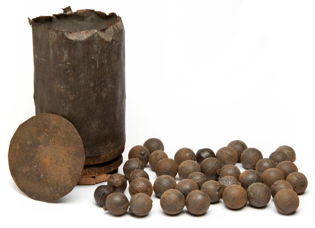 Artillery shot-canister for a 12-pounder cannon. The canister has a wood sabot, iron dividing plate, and thirty-seven cast-iron grape shot. The grapeshot all have mold-seam lines, and some have sprue projections. (Wikimedia Commons)