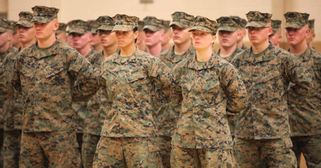 U.S. Marines PFC. Cristina Fuentes Montenegro (Center Left) and PFC. Julia R. Carroll (Center Right) of Delta Company, Infantry Training Battalion, School of Infantry - East (SOI-E), stand at parade rest during their graduation ceremony from SOI-E aboard Camp Geiger, N.C., Nov. 21, 2013. (U. S. Marine Corps photo by LCpl. Nicholas J. Trager, Combat Camera, SOI-E/Released)