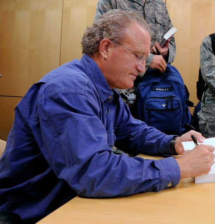 Mark Bowden signs books while visiting the U.S. Air Force Academy. (U.S. Air Force photo by Mike Kaplan)