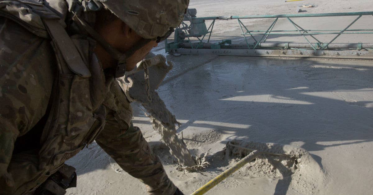 A USAF Airman assigned to the 1st Expeditionary Civil Engineering Group, spreads concrete at Qayyarah West Airfield, Iraq, Oct. 10, 2016. Photo by Pfc. Christopher Brecht