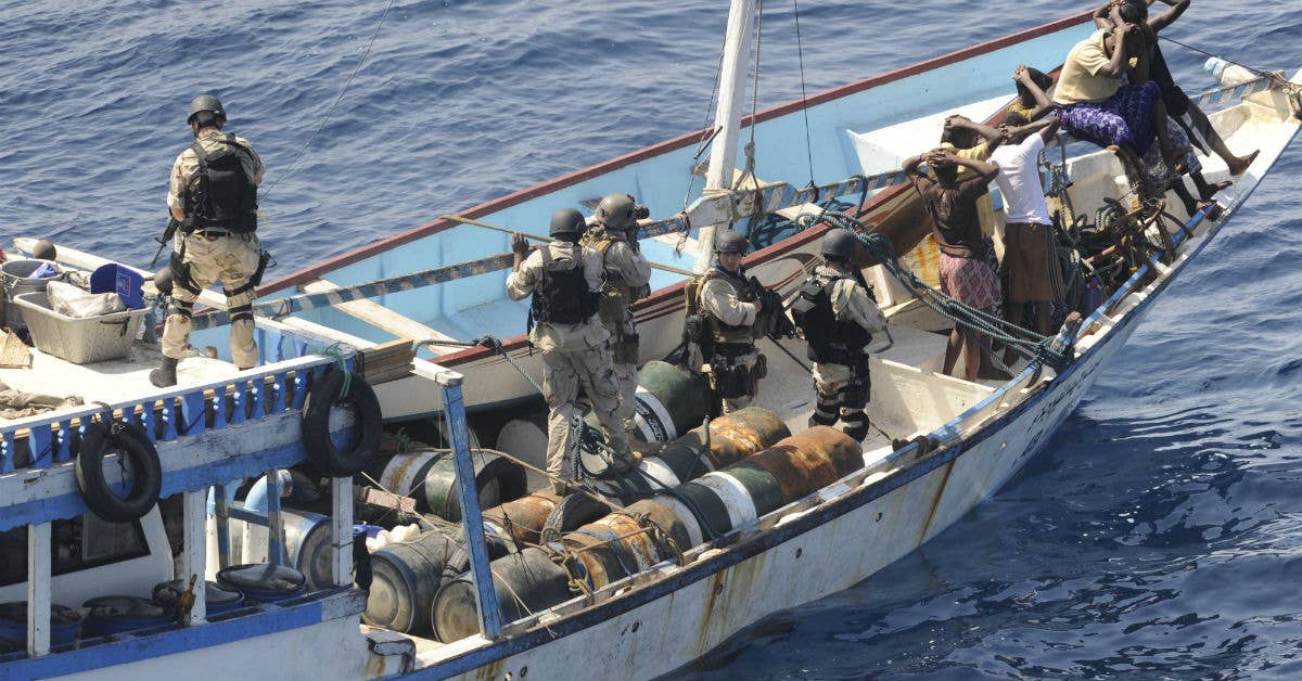 Members of a visit, board, search and seizure team from the guided-missile cruiser USS Chosin keep watch over the crew of a suspected pirate dhow. Navy photo by Mass Communication Specialist 1st Class Scott Taylor.