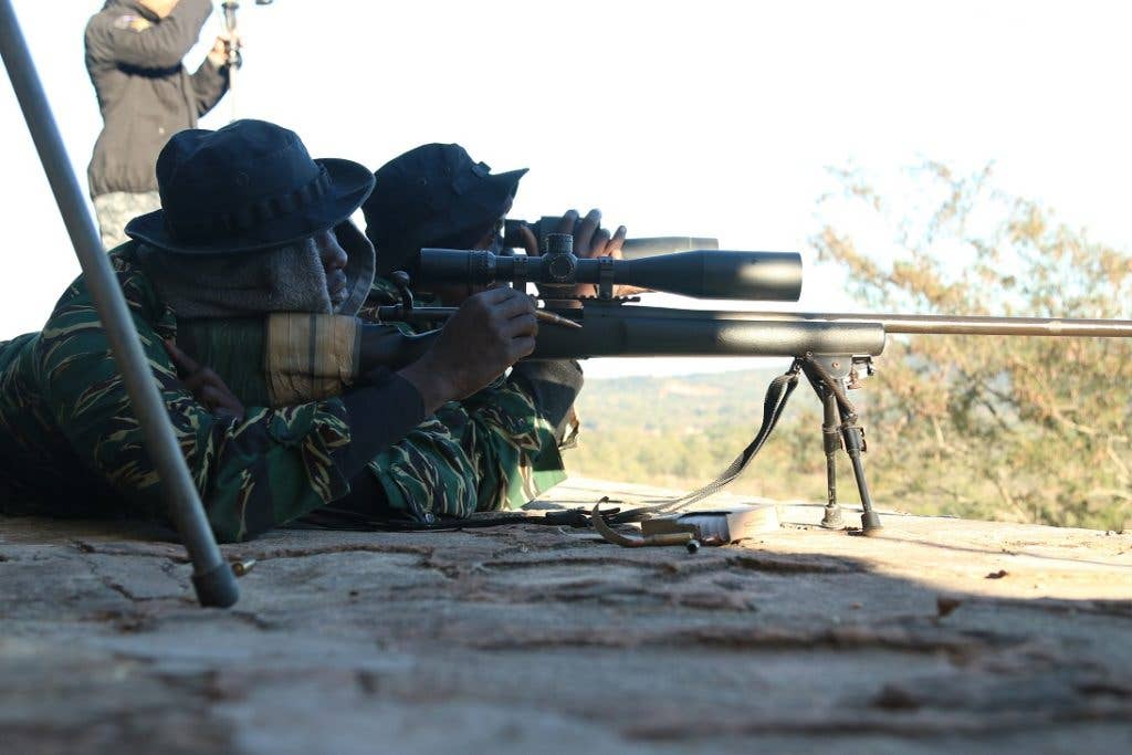 A Guyanese sniper loads a round into his rifle while his teammate scans the range for targets. (U.S. Army photo by Spc. Elizabeth Williams)