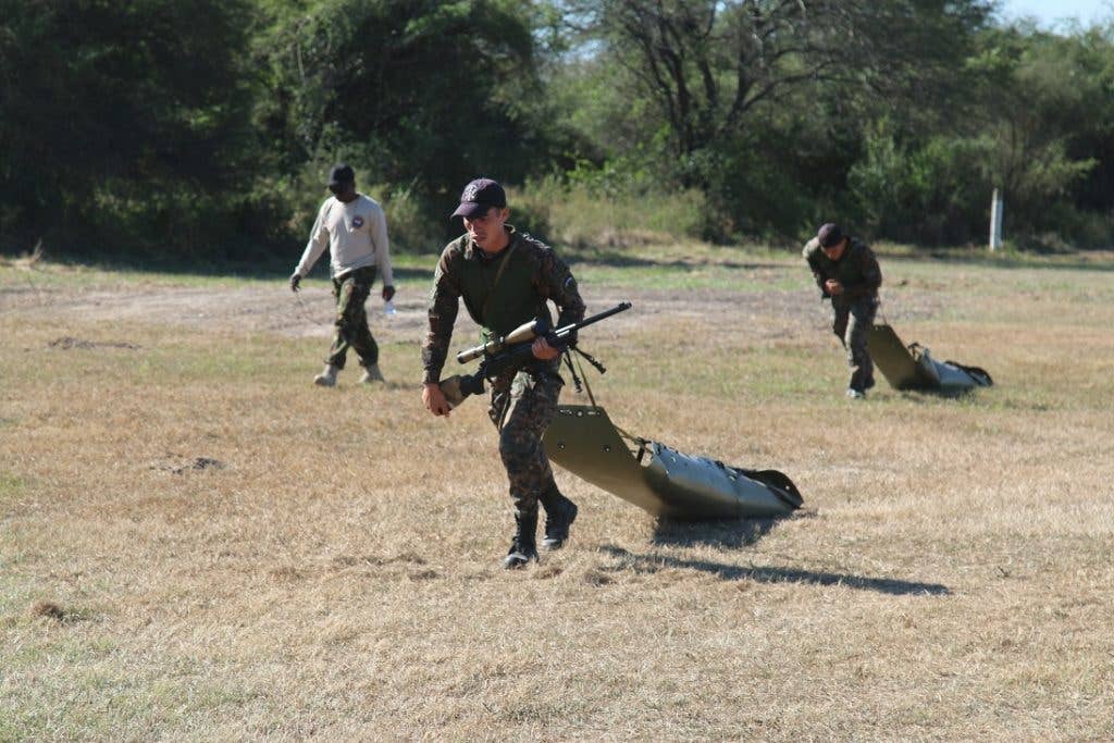 Competitors drag litters 100 meters then work together to haul them onto a platform. (U.S. Army photo by Sgt. 1st Class James Brown)