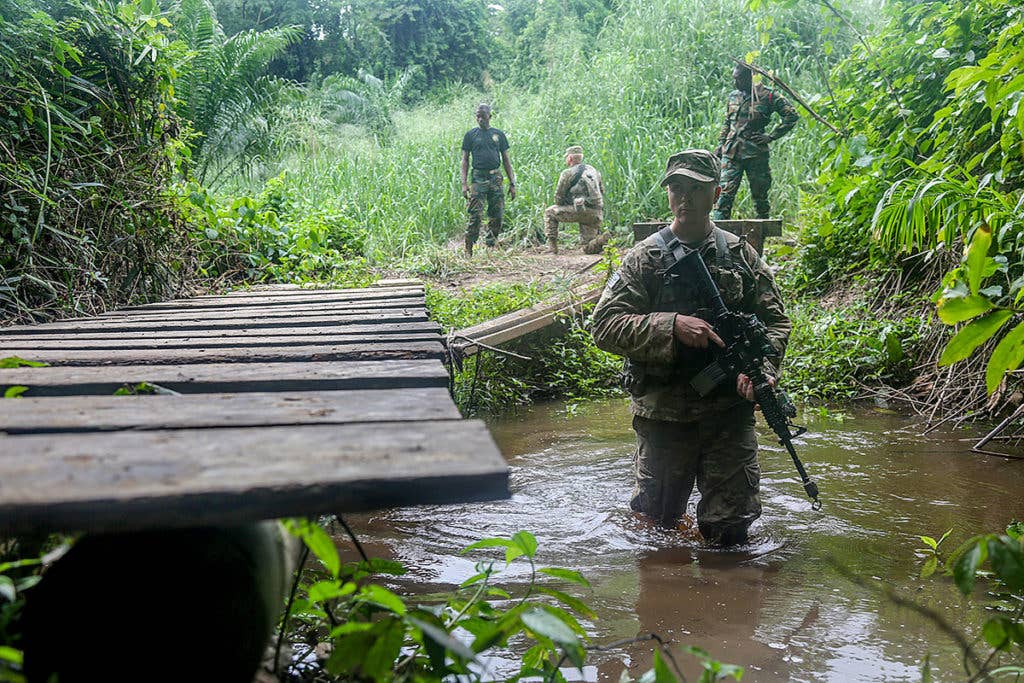 Army Spc. Jake Burley assigned to the 1st Battalion, 506th Infantry Regiment, 1st, Brigade Combat Team, 101st Airborne Division maneuvers through a river during United Accord 2017 at the Jungle Warfare School on Achiase military base, Akim Oda, Ghana, May 26, 2017. (U.S. Army photo by Sgt. Brian Chaney)