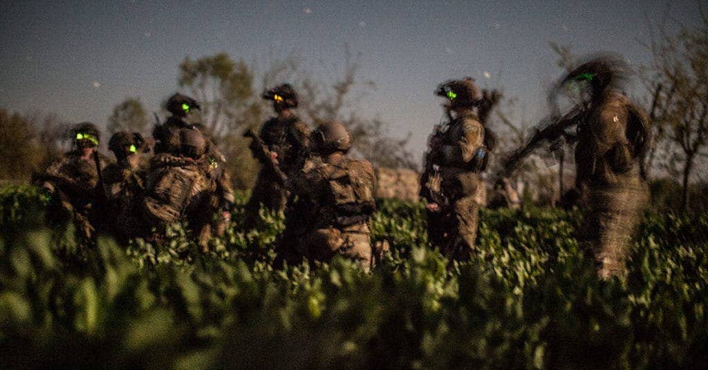 Members of an Afghan and coalition security force move into a field of grass during an operation in Khugyani district, Nangarhar province, Afghanistan, March 30, 2013. (U.S Army photo by Pfc. Elliott N. Banks)