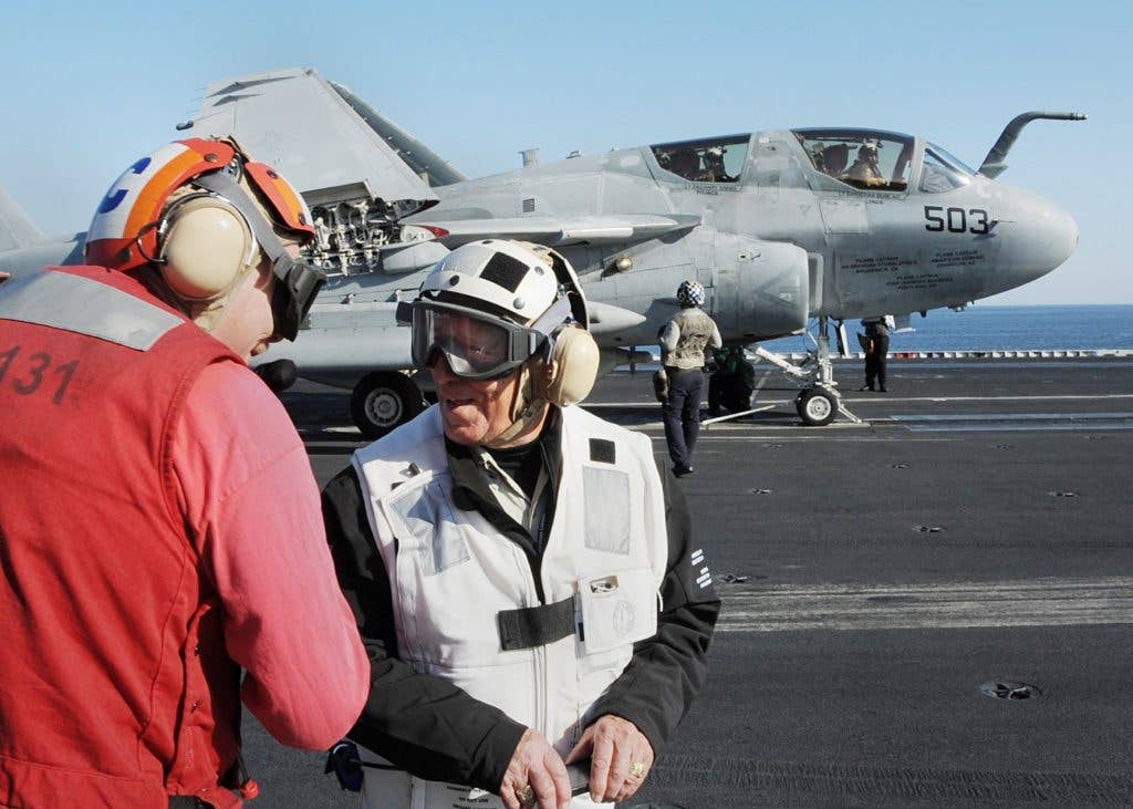 Auto racing legend Mario Andretti observes flight operations aboard the aircraft carrier USS Abraham Lincoln during a visit to the ship as part of the centennial celebration of the Indianapolis 500 auto race. The Abraham Lincoln Carrier Strike Group is deployed in the U.S. 5th Fleet area of responsibility in support of maritime security operations and theater cooperation efforts.