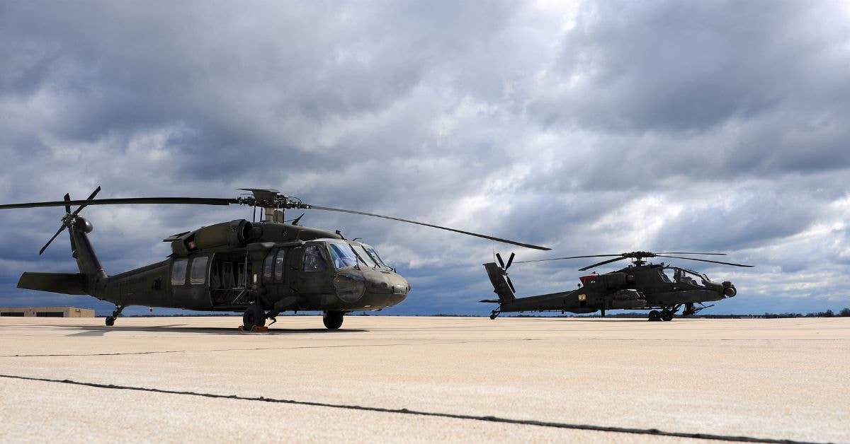 A Missouri Army National Guard UH-60 Black Hawk utility helicopter (left) sits next to an AH-64 Apache attack helicopter on the flightline. USAF photo by Airman 1st Class Michaela R. Slanchik.