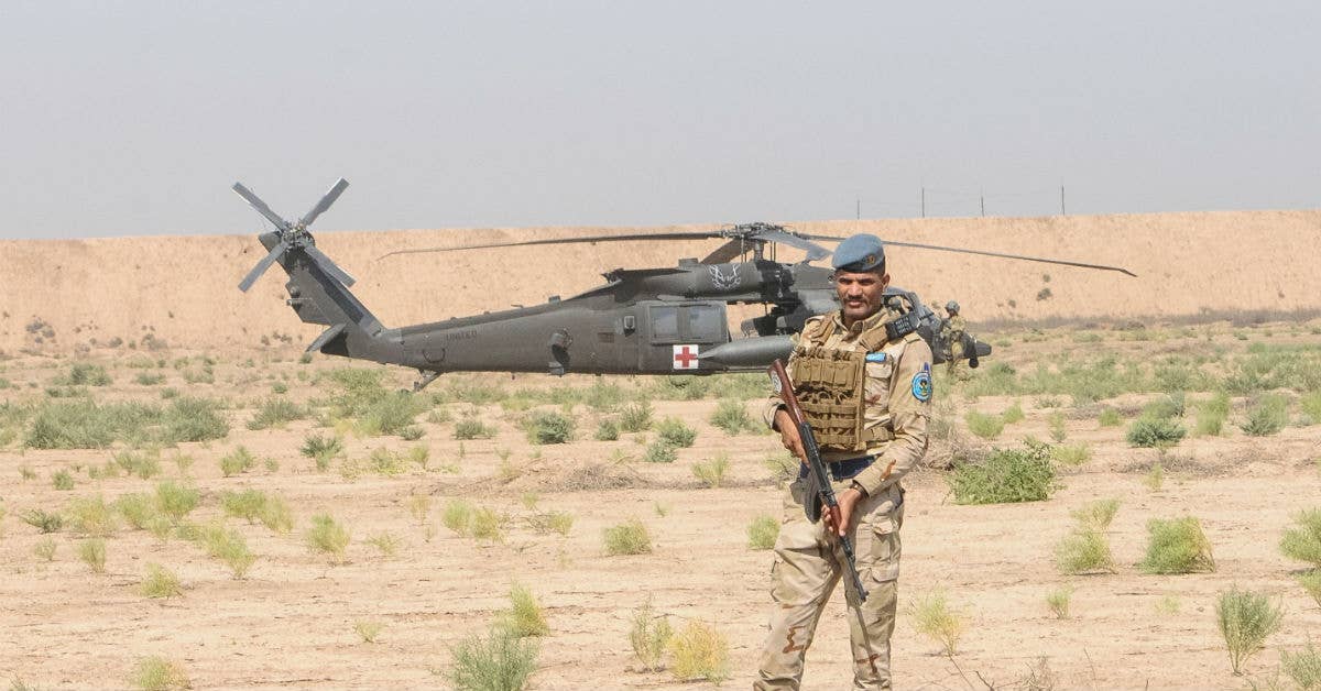 A member of the Iraqi Security Forces establishes a security perimeter around an HH-60M Black Hawk helicopter. Photo by Capt. Stephen James.
